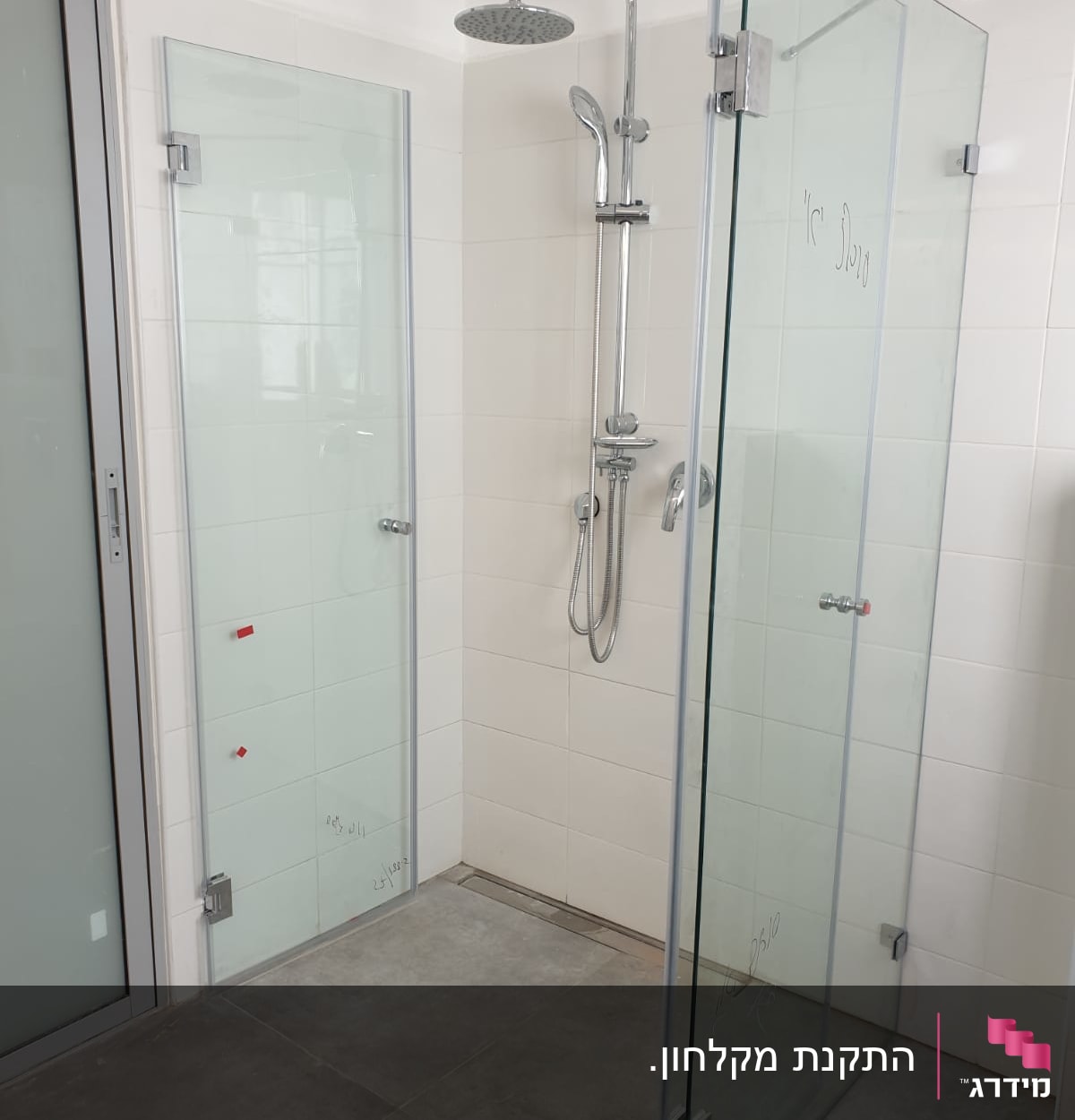 מקלחת עם דלתות זכוכית וראש מקלחת מתכתי